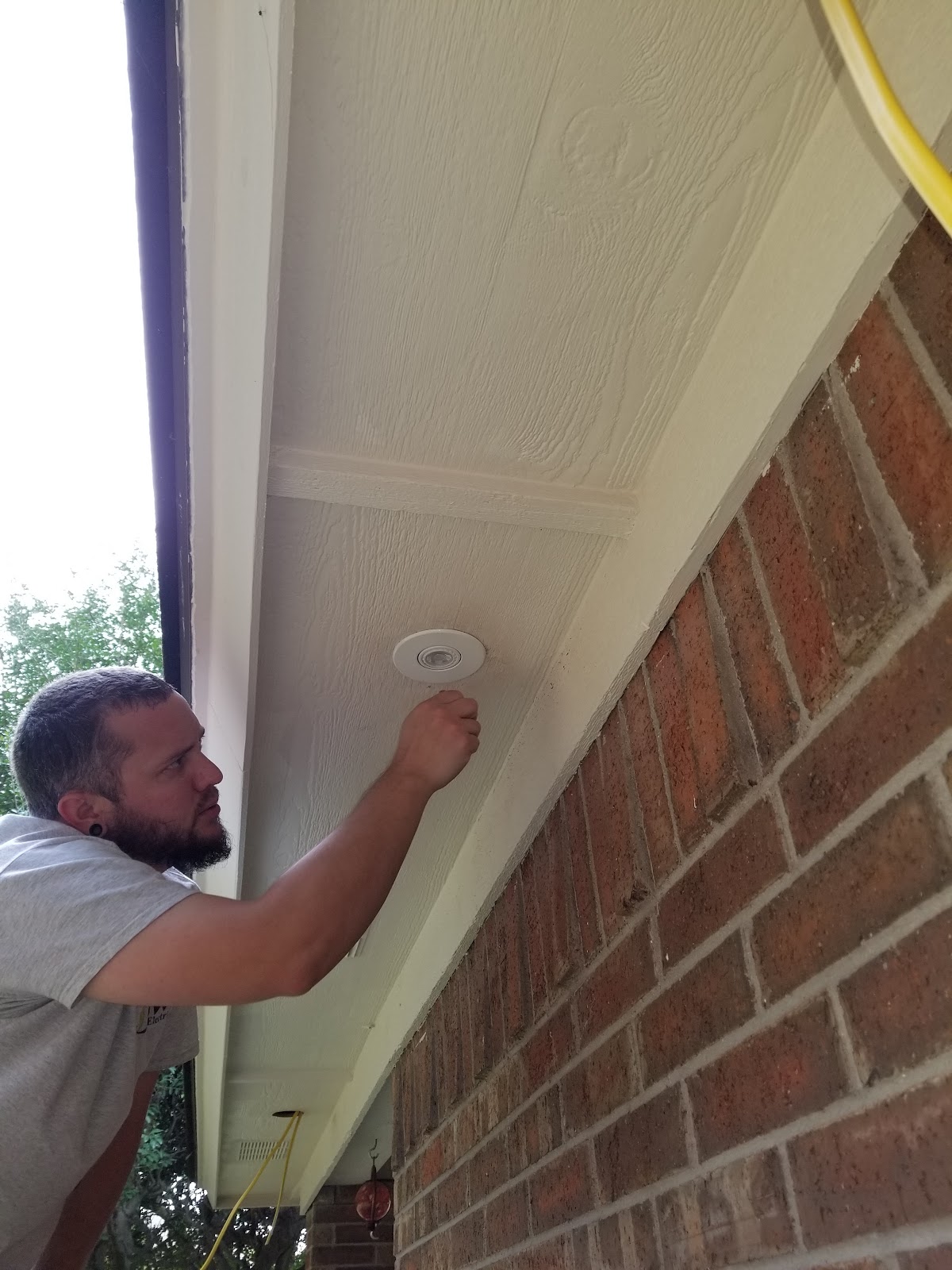 DW Electric technician installing a recessed light fixture